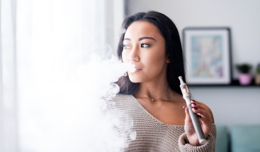 Junge Frau „raucht“ E-Zigarette